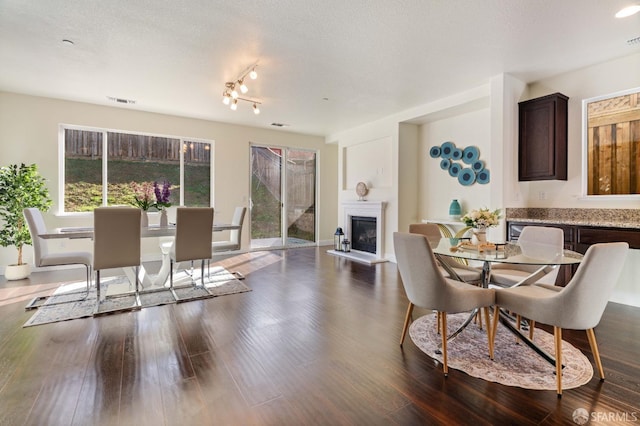 dining room featuring dark hardwood / wood-style flooring and a textured ceiling