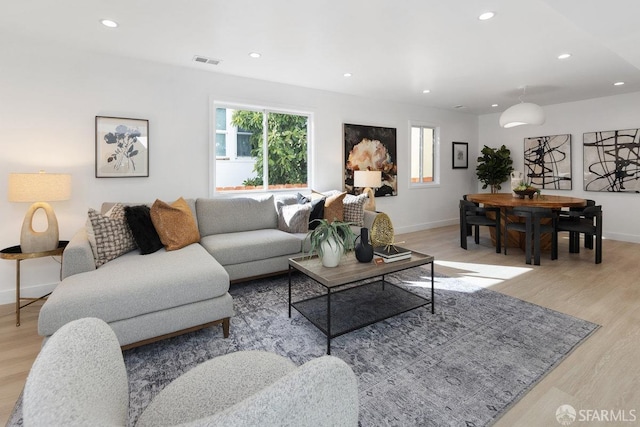 living area with light wood-type flooring, baseboards, visible vents, and recessed lighting