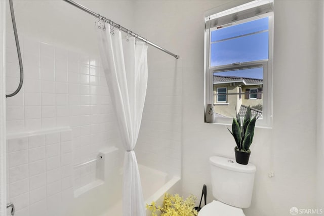 bathroom featuring shower / bathtub combination with curtain and toilet