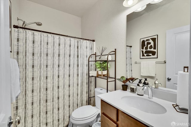 bathroom featuring vanity, walk in shower, and toilet