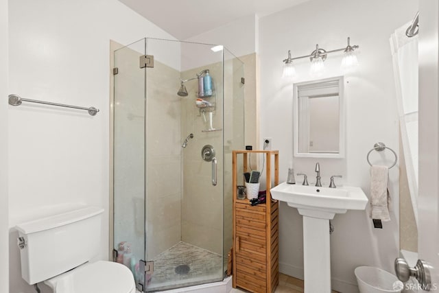 bathroom with sink, a shower with shower door, and toilet