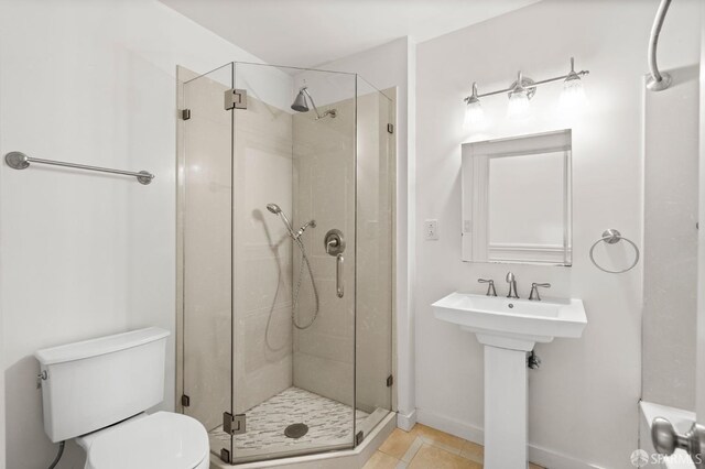 bathroom featuring tile patterned flooring, toilet, and an enclosed shower