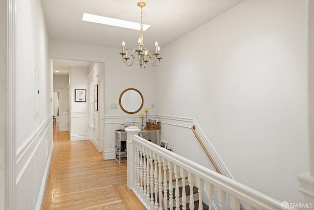 hallway featuring light wood-type flooring and a chandelier