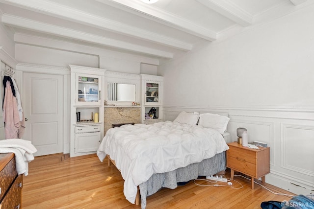 bedroom featuring beamed ceiling and light hardwood / wood-style flooring