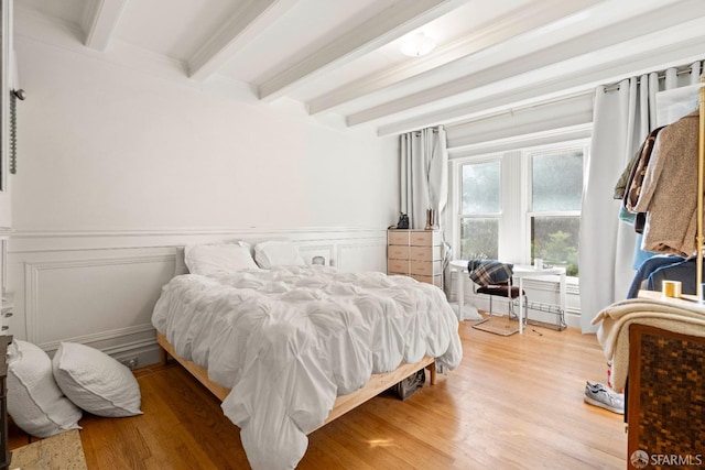 bedroom featuring beam ceiling and light wood-type flooring