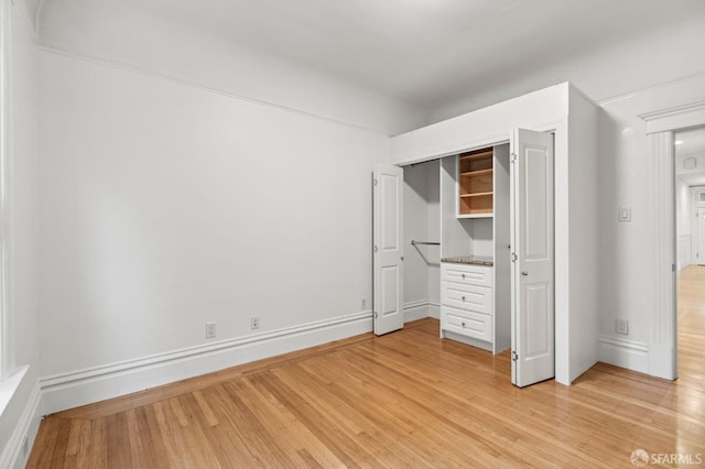 unfurnished bedroom with light hardwood / wood-style flooring and a closet