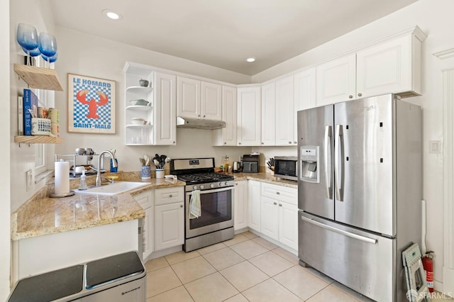 kitchen with white cabinets, sink, light tile patterned floors, kitchen peninsula, and stainless steel appliances