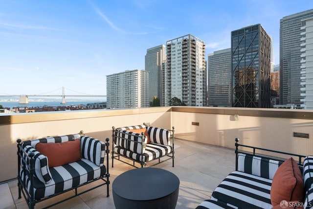 view of patio / terrace with a balcony, a view of city, and an outdoor living space