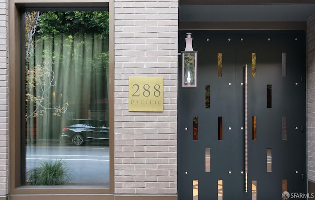 entrance to property featuring elevator and brick siding