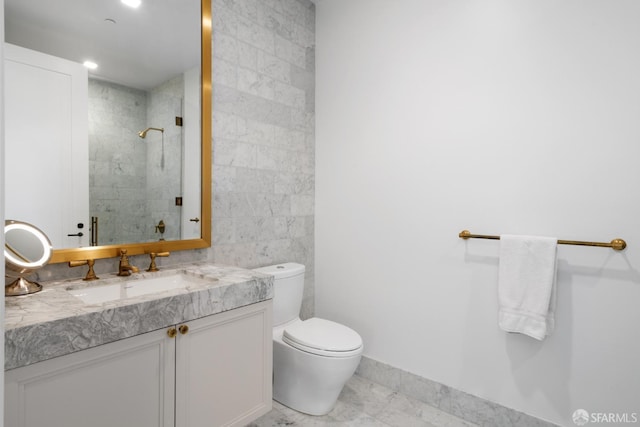 full bathroom featuring toilet, tiled shower, vanity, and tile walls