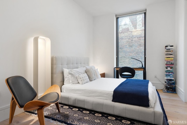 bedroom with light wood-type flooring and expansive windows