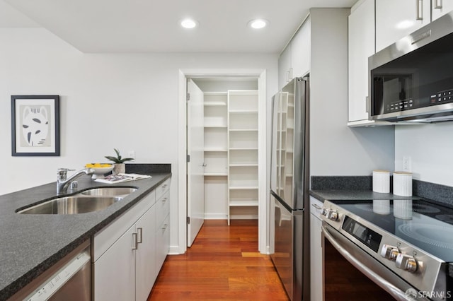 451 Kansas St Unit 428, San Francisco, CA 94107 - kitchen with stainless steel appliances, dark wood-type flooring, recessed lighting, and white cabinets