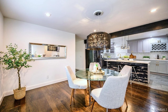 dining space with beam ceiling, baseboards, a chandelier, and dark wood-style flooring