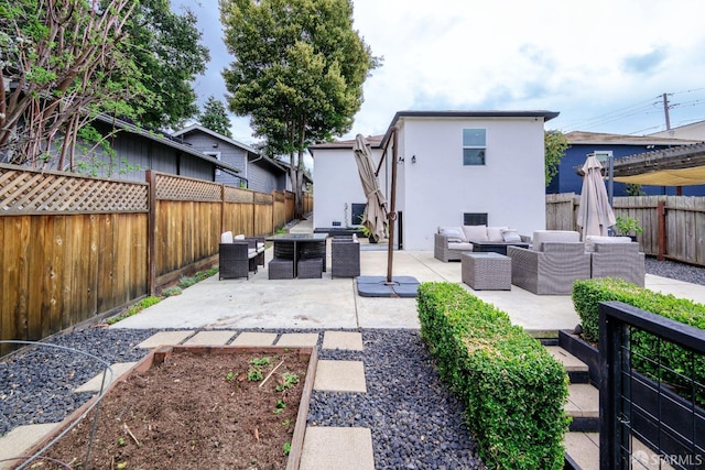 back of house featuring a patio, outdoor lounge area, a fenced backyard, and stucco siding