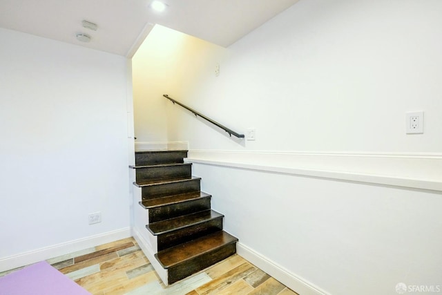 staircase with baseboards and wood finished floors