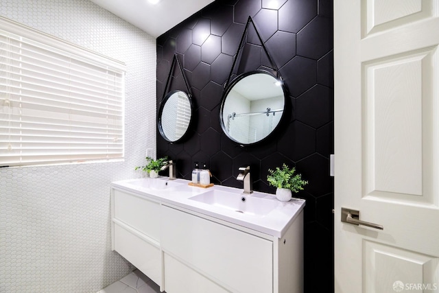 bathroom with double vanity, tile walls, and a sink