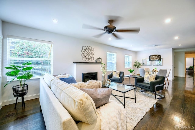 living room featuring baseboards, ceiling fan, dark wood-type flooring, a fireplace, and recessed lighting