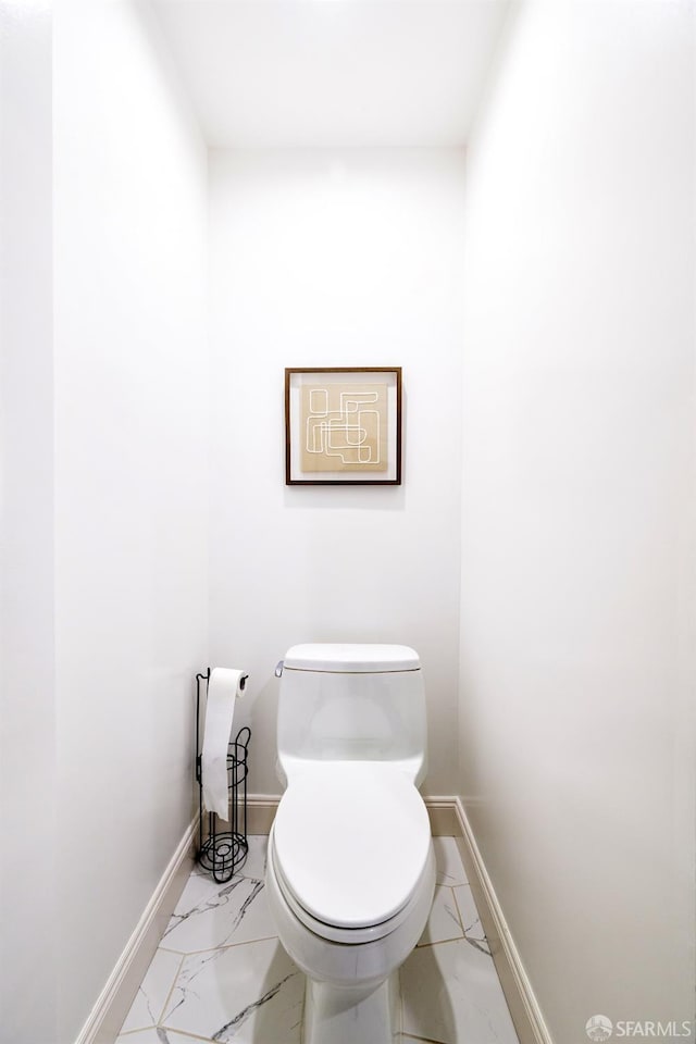 bathroom with marble finish floor, toilet, and baseboards