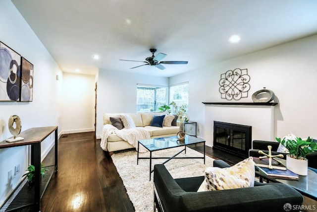 living area with baseboards, a ceiling fan, a fireplace with flush hearth, wood finished floors, and recessed lighting