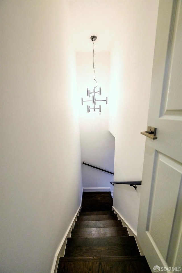 staircase featuring baseboards and wood finished floors