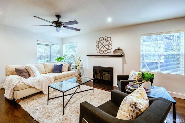 living room with ceiling fan, recessed lighting, dark wood-type flooring, a fireplace with flush hearth, and baseboards