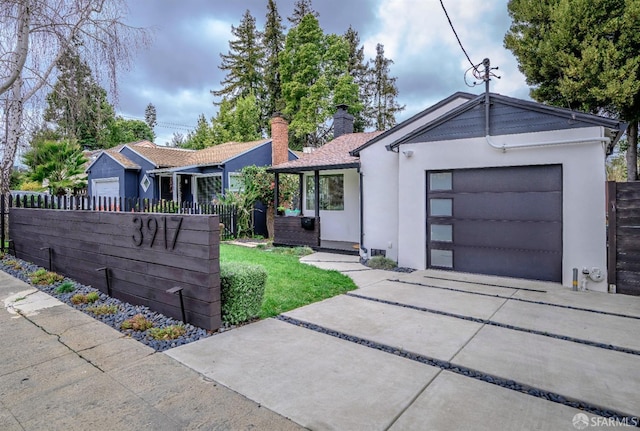 ranch-style home featuring an attached garage, fence, driveway, stucco siding, and a chimney