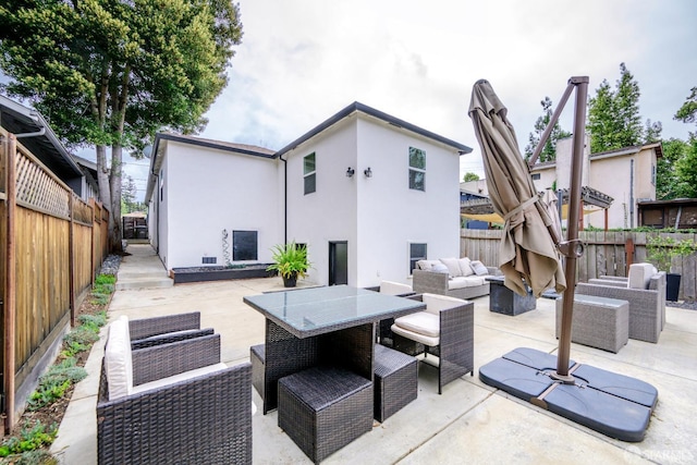 rear view of house with a patio area, a fenced backyard, an outdoor hangout area, and stucco siding