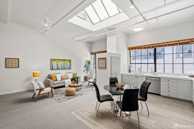 dining room with sink, track lighting, and a skylight