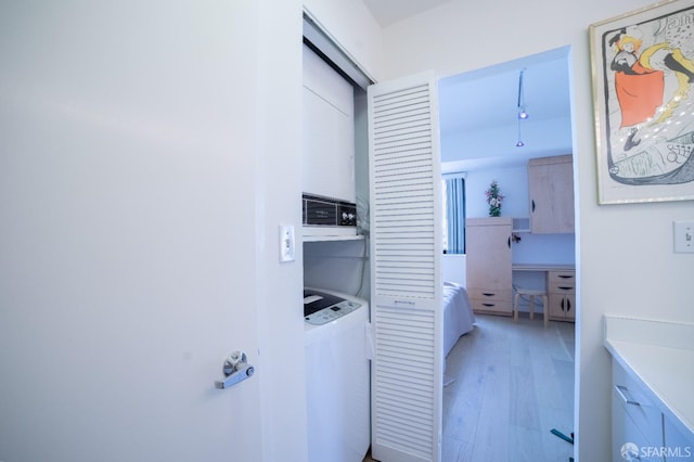 clothes washing area with light hardwood / wood-style flooring