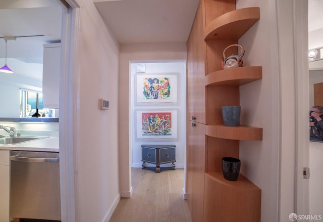 hall with light wood-type flooring and sink