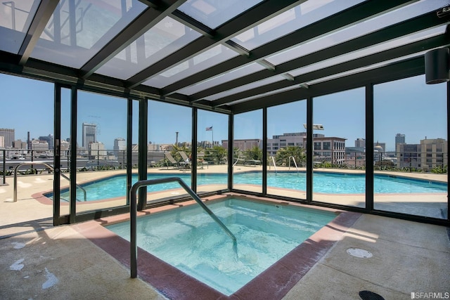 view of swimming pool with a patio area and a hot tub