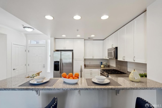 3901 Lick Mill Blvd Unit 165, Santa Clara, CA 95054 - kitchen featuring stainless steel appliances, a peninsula, light stone countertops, white cabinets, and recessed lighting
