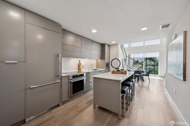 1605 Riviera Ave Unit 608, Walnut Creek, CA 94596 - kitchen with built in appliances, modern cabinets, gray cabinetry, light countertops, and a center island