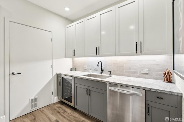 interior space featuring beverage cooler, visible vents, gray cabinets, stainless steel dishwasher, and a sink