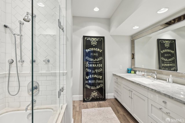 bathroom with shower / bath combination with glass door, wood finished floors, vanity, and recessed lighting