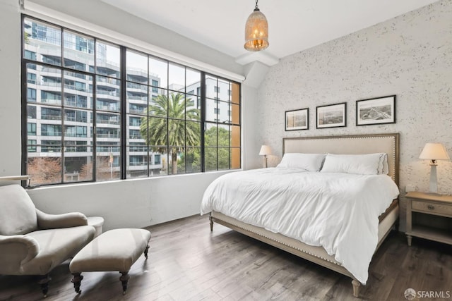 bedroom featuring wallpapered walls and wood finished floors