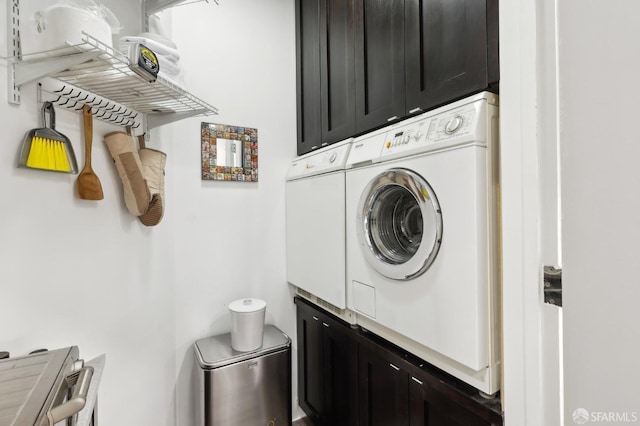 clothes washing area featuring stacked washer / drying machine and cabinet space