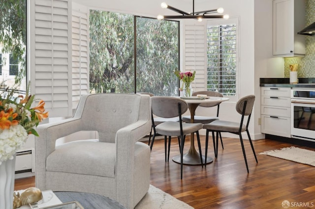 dining room featuring a baseboard radiator, a notable chandelier, and dark wood-type flooring