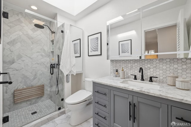 bathroom with marble finish floor, backsplash, toilet, a stall shower, and vanity