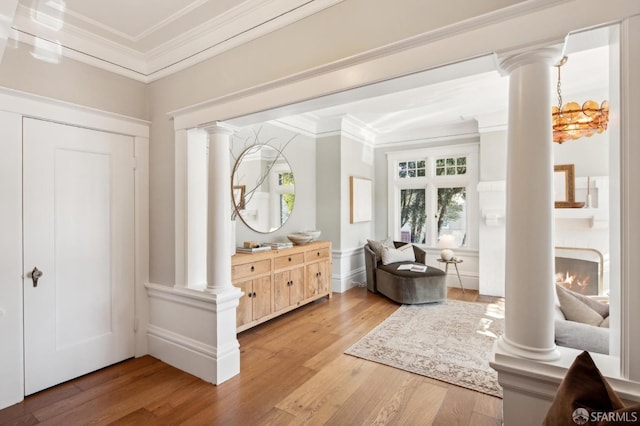 interior space featuring hardwood / wood-style flooring, crown molding, and a fireplace