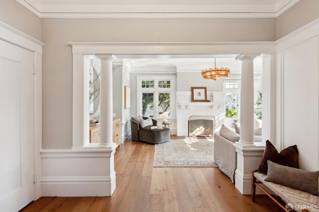 interior space with a notable chandelier, ornamental molding, and light hardwood / wood-style floors