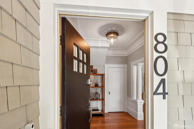 hallway featuring hardwood / wood-style flooring and crown molding