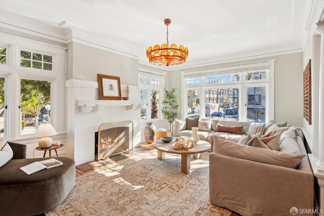 living room featuring a wealth of natural light, crown molding, and an inviting chandelier