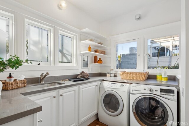 laundry room featuring washer and clothes dryer, sink, and cabinets