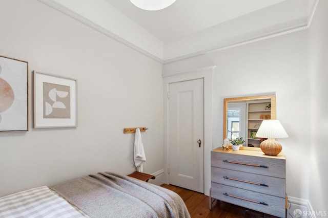 bedroom with dark hardwood / wood-style floors and crown molding