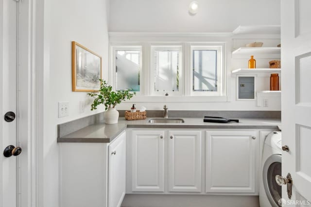 interior space with white cabinetry, washer / clothes dryer, and sink