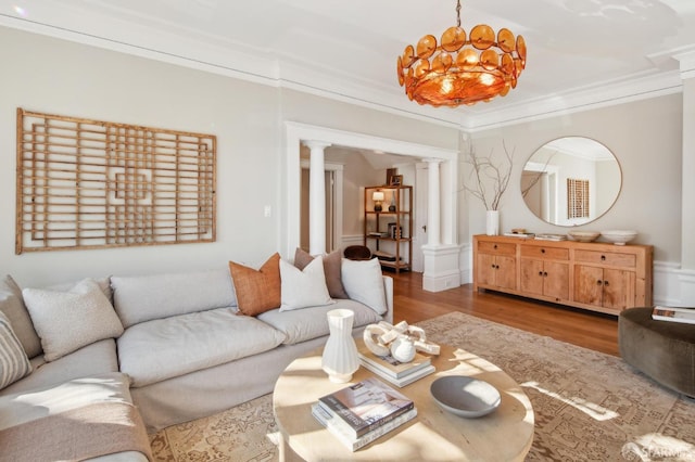 living room with hardwood / wood-style floors, ornamental molding, ornate columns, and a chandelier