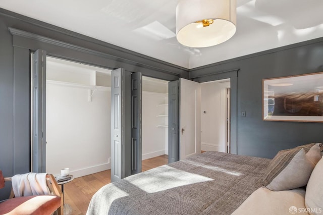 bedroom featuring ornamental molding and light hardwood / wood-style flooring