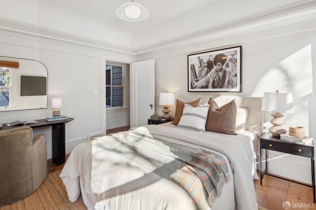 bedroom featuring ornamental molding and light hardwood / wood-style floors