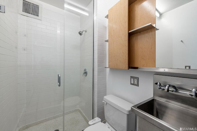 bathroom with visible vents, a shower stall, toilet, and vanity